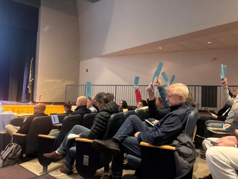 Residents attending a public meeting in an auditorium
