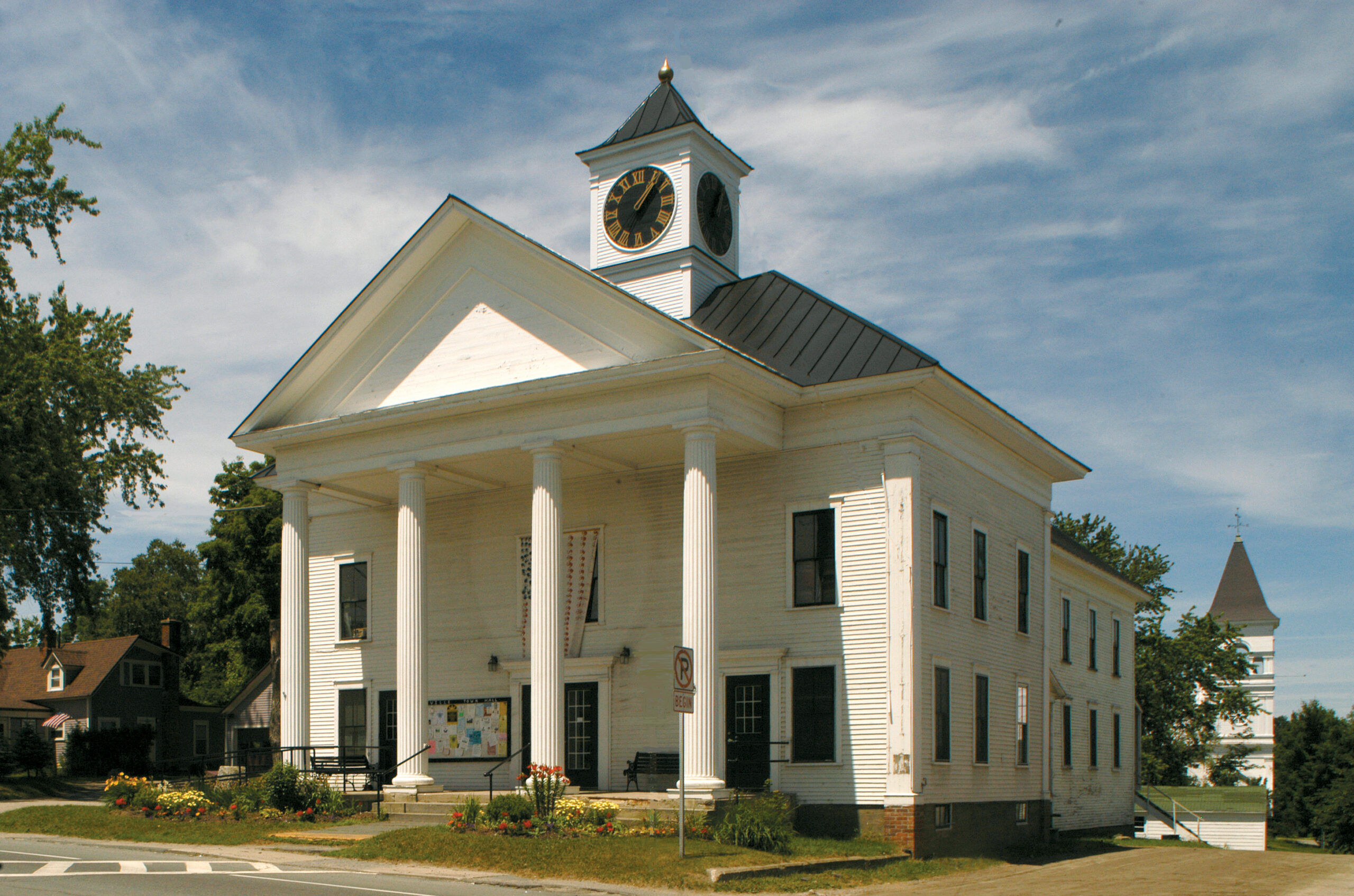 White columned municipal building with a clock tower