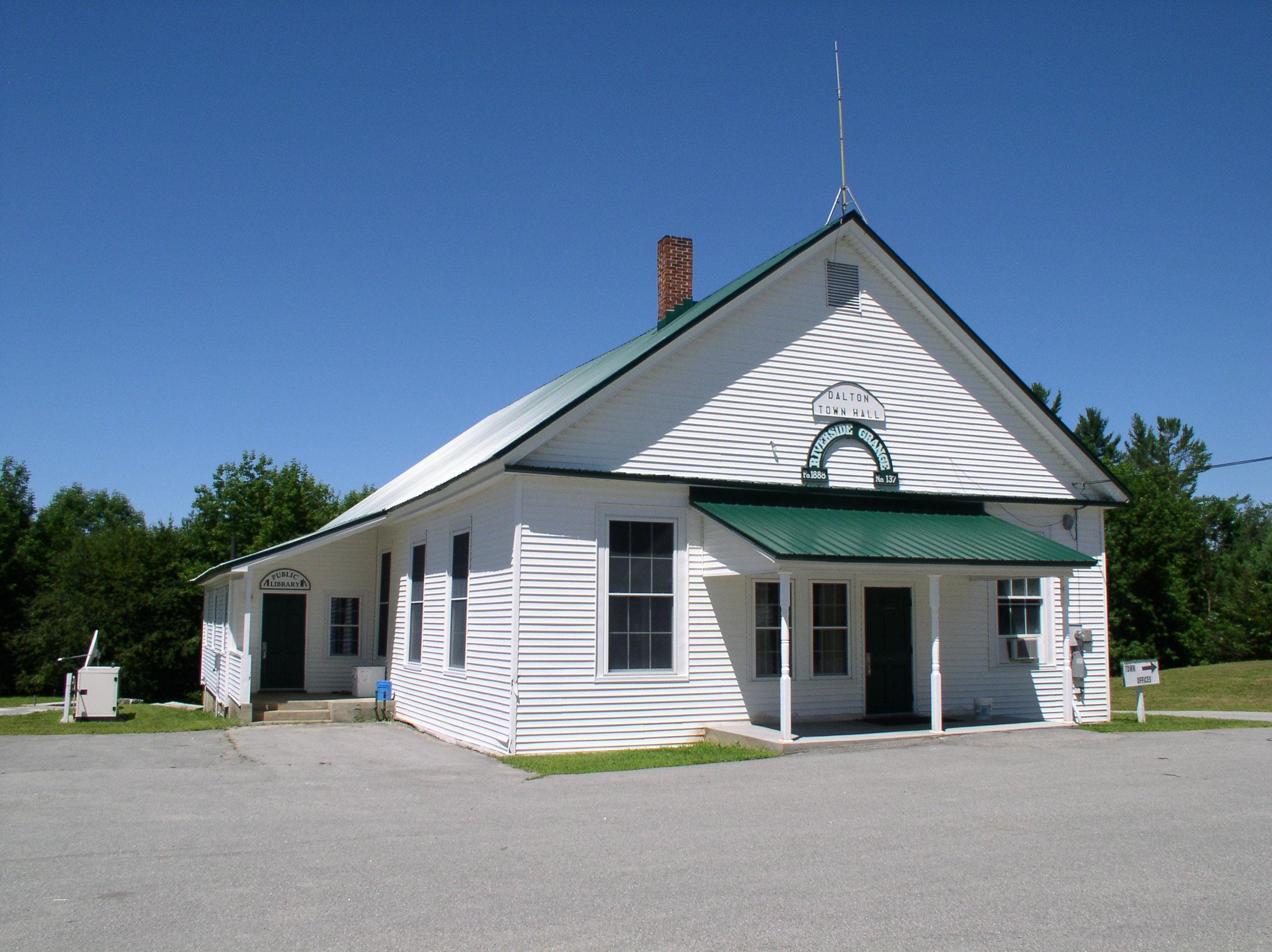 White clapboard town building with a central entrance and roof cupola