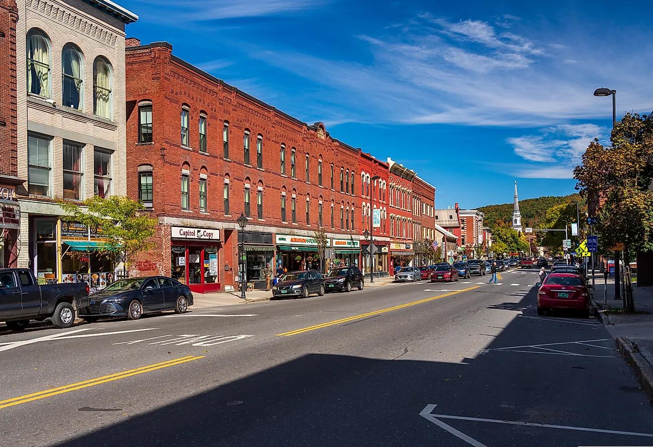 Brick storefronts and parked vehicles along a downtown street
