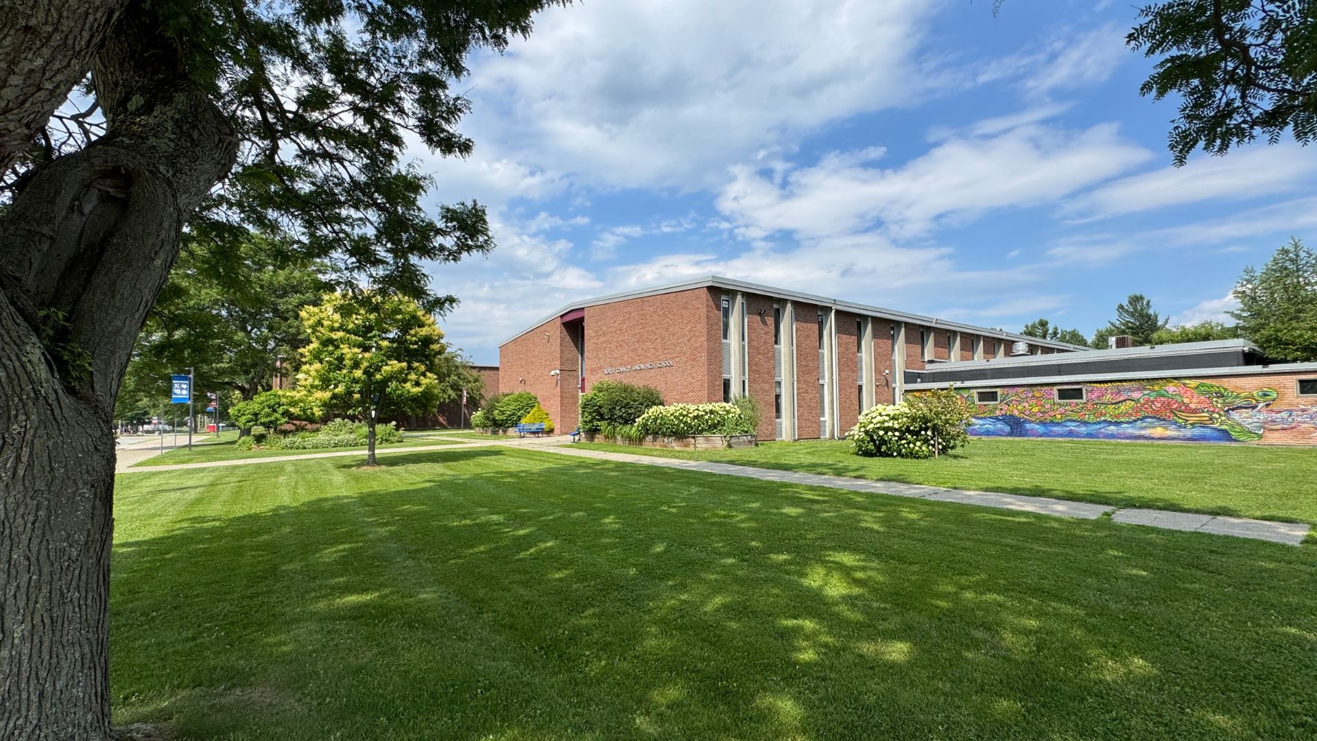 School building with trees and a green lawn