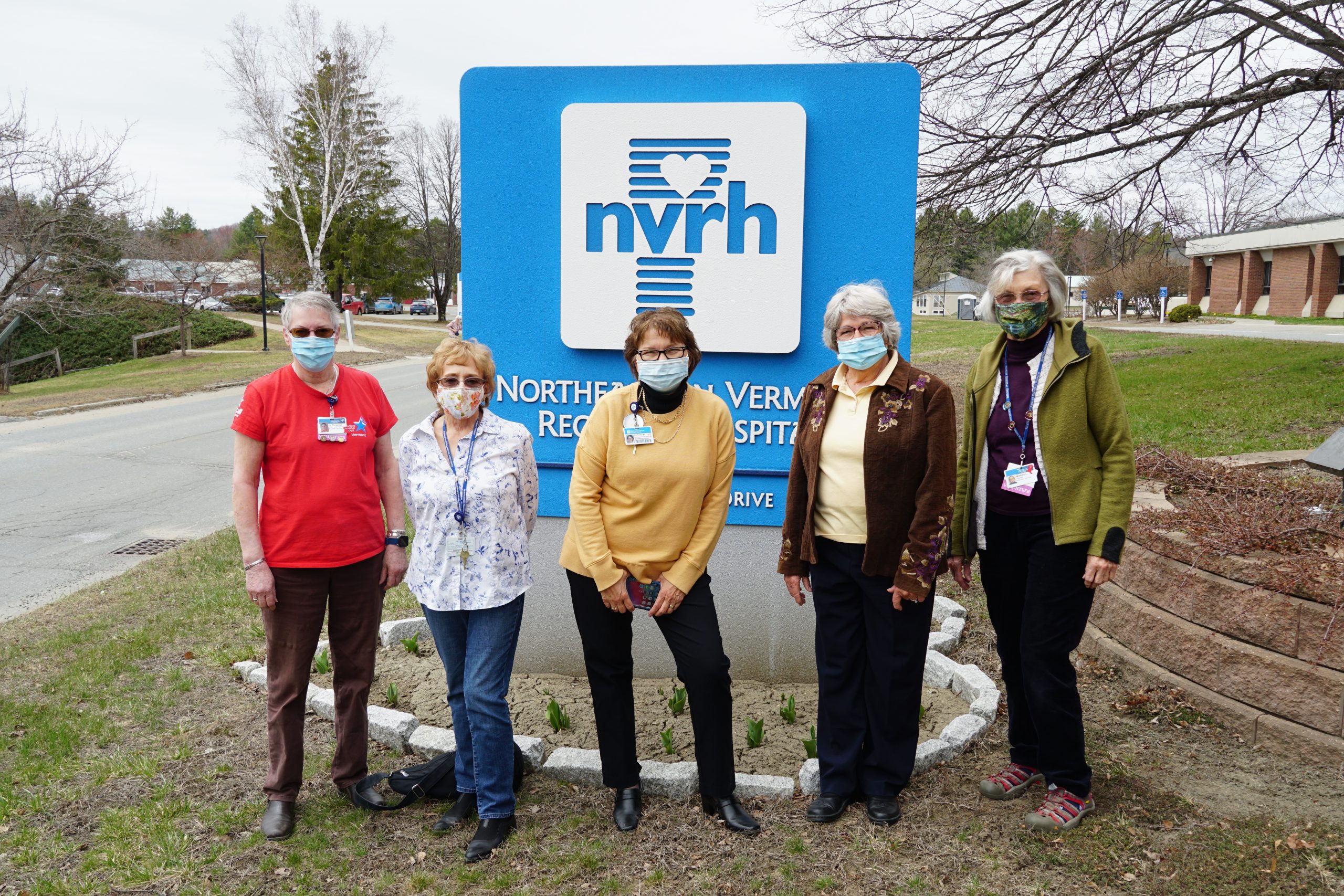 Volunteers standing beside the NVRH hospital sign