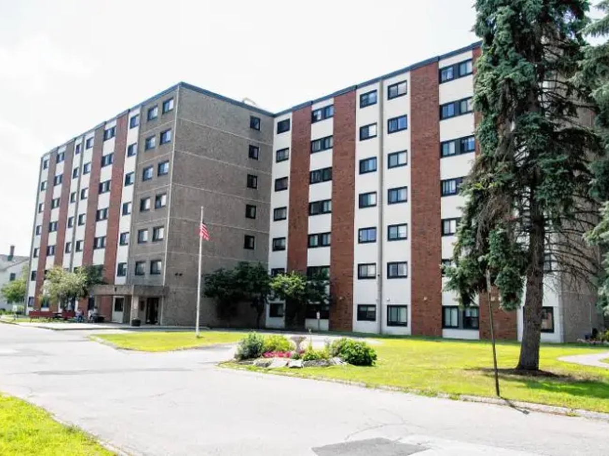 Multistory residential building with a lawn and sidewalk