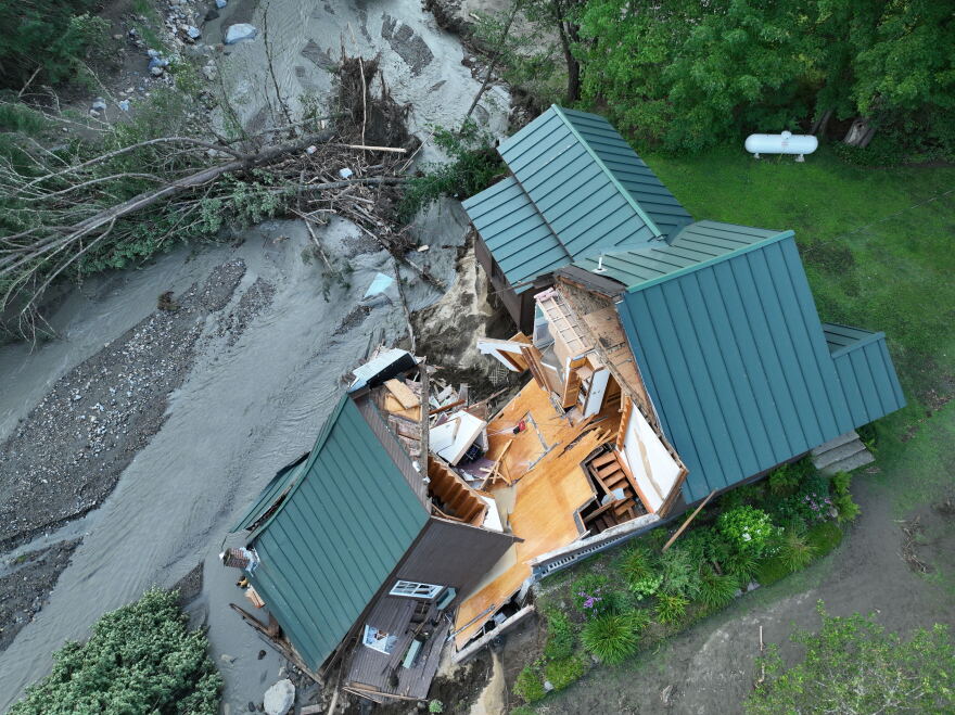 Aerial view of storm damage to a building beside a road
