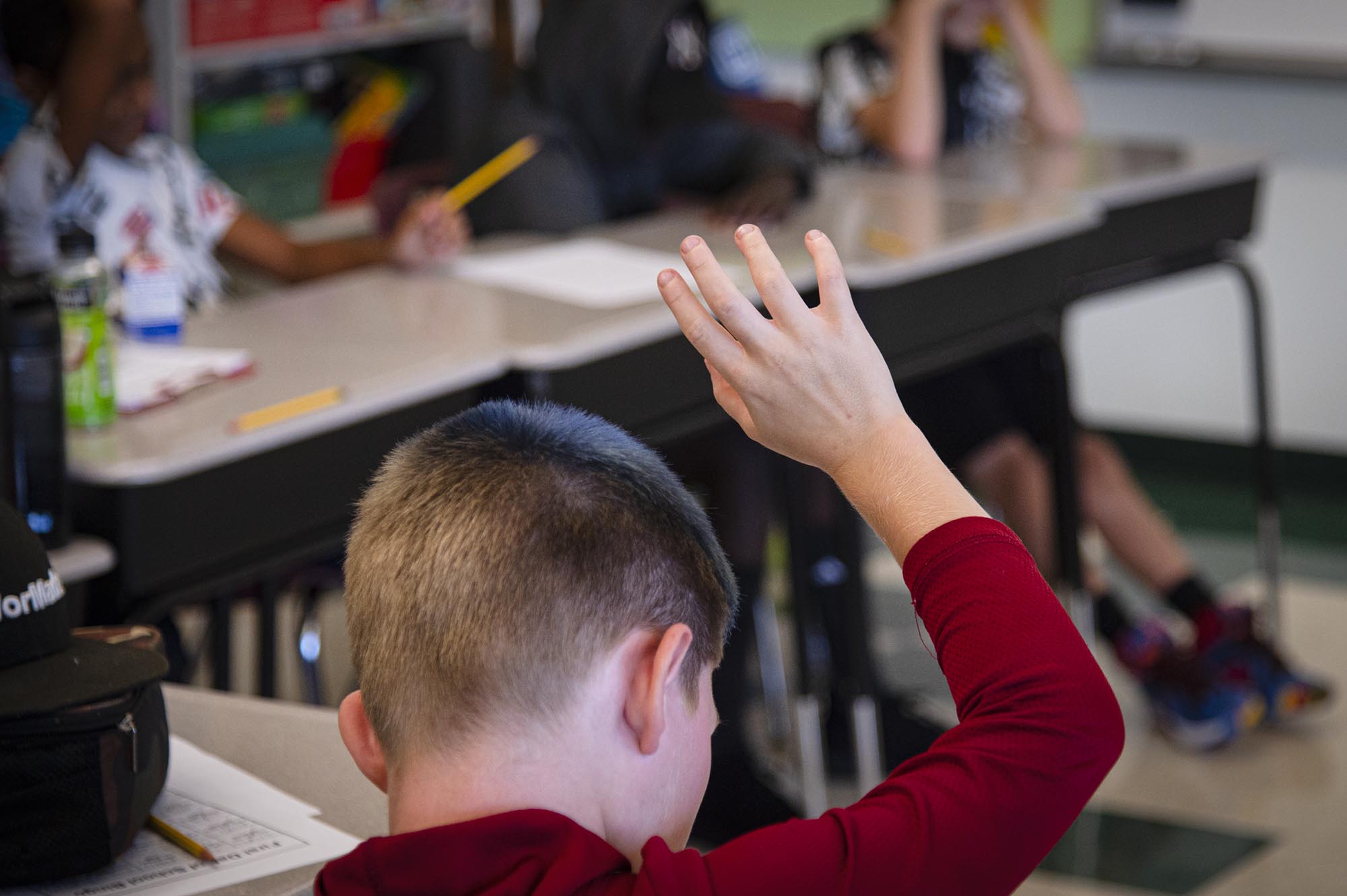 Student raising a hand in a classroom