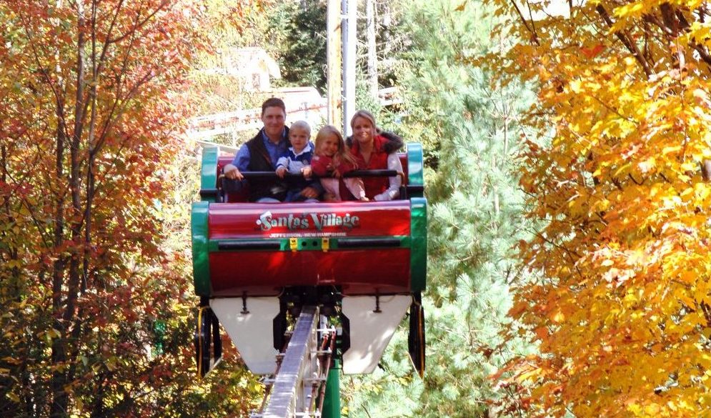 Family riding in a horse-drawn wagon through autumn foliage