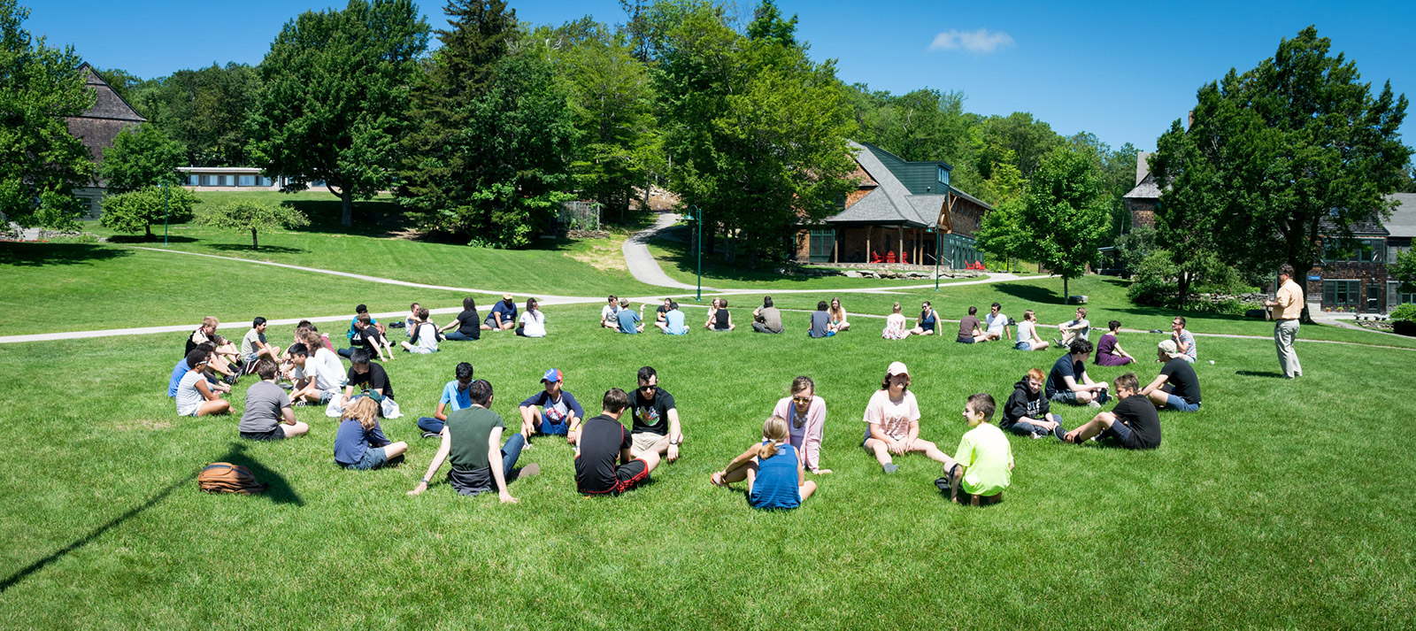 Students gathered in circles on a campus lawn