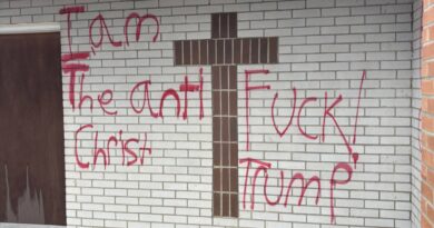 Red spray-painted graffiti on a property along Main Street in Lancaster, New Hampshire