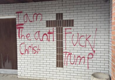 Red spray-painted graffiti on a property along Main Street in Lancaster, New Hampshire