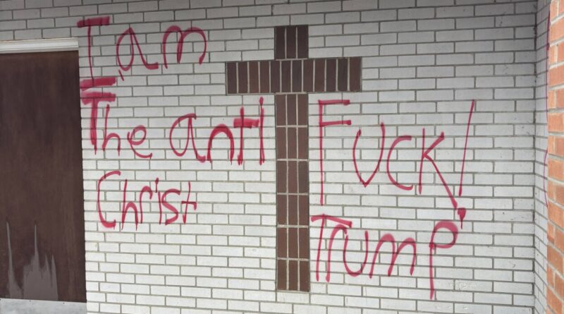 Red spray-painted graffiti on a property along Main Street in Lancaster, New Hampshire