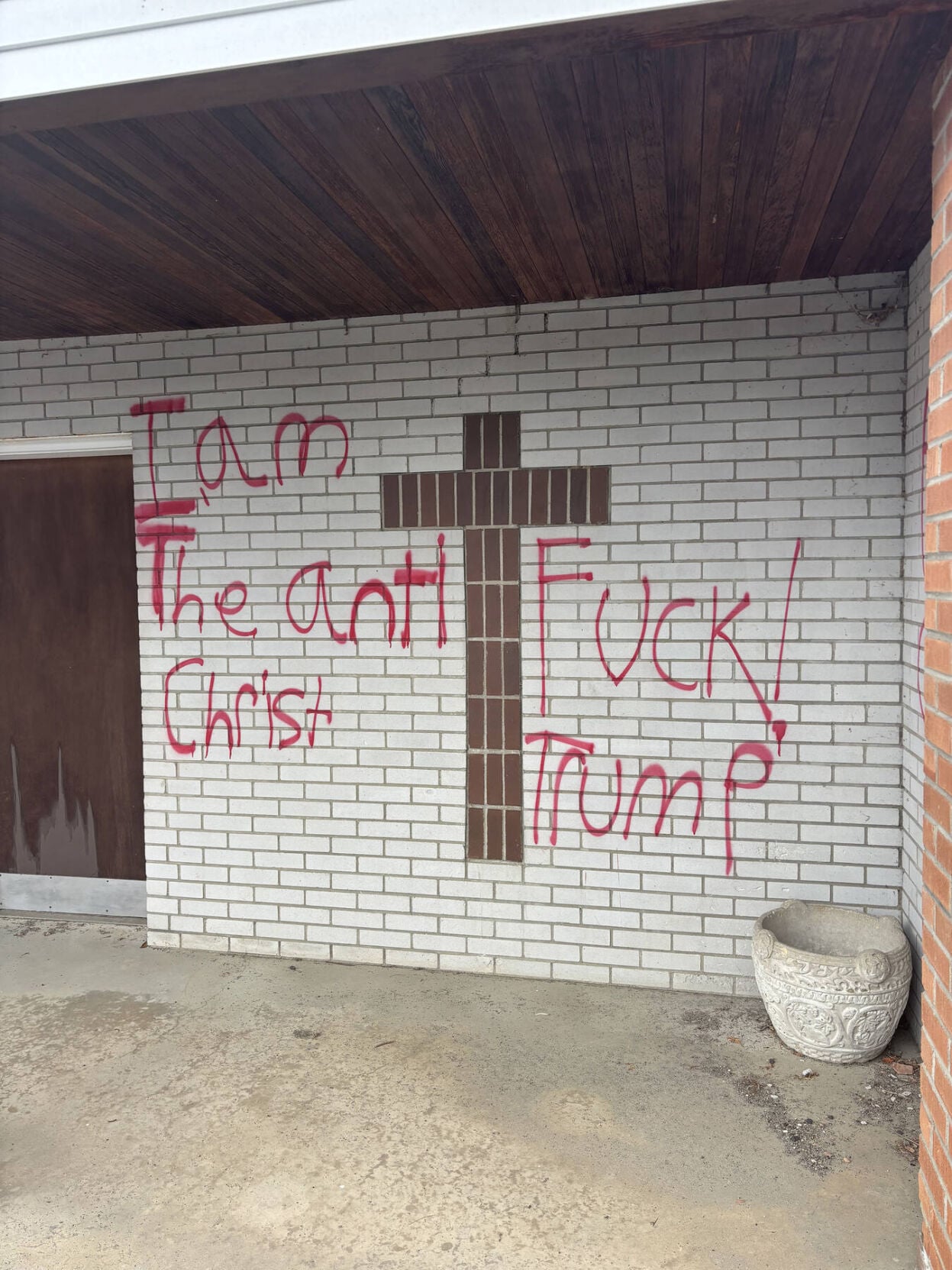 Red spray-painted graffiti on a property along Main Street in Lancaster, New Hampshire